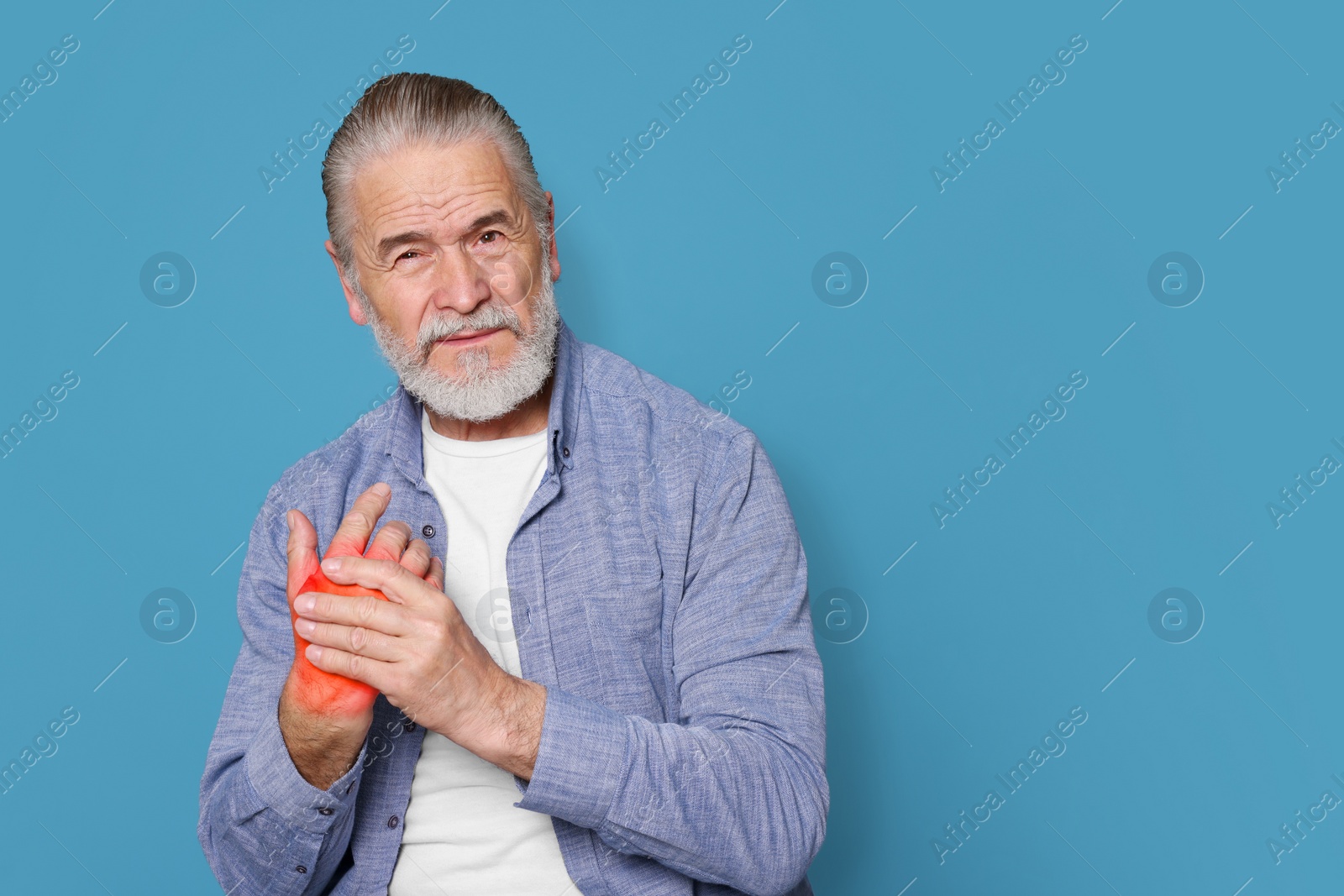 Image of Arthritis symptoms. Senior man suffering from pain in hand on light blue, space for text