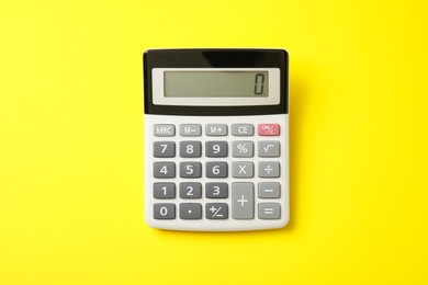 Calculator on yellow background, top view. Office equipment