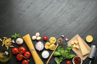 Different types of pasta, spices, garter and products on dark textured table, flat lay. Space for text