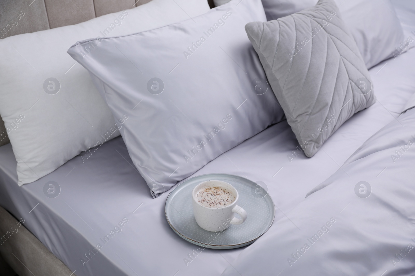 Photo of Cup of coffee on bed with soft silky bedclothes