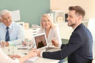 Photo of Group of people discussing ideas at table in office. Consulting service concept