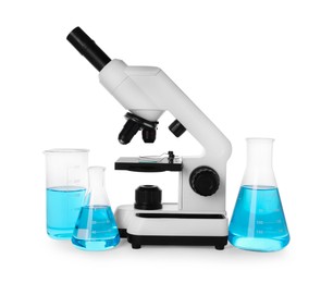 Laboratory glassware with light blue liquid and microscope isolated on white