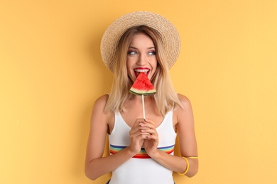 Pretty young woman with juicy watermelon on color background