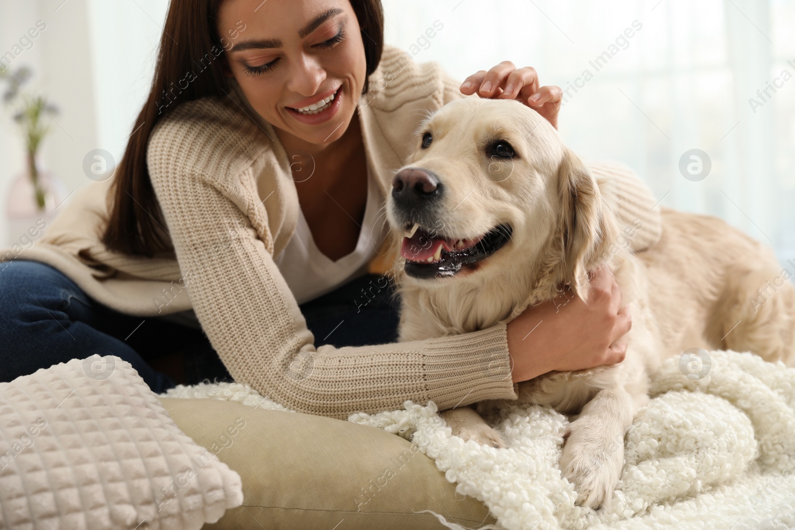 Photo of Young woman and her Golden Retriever at home. Adorable pet