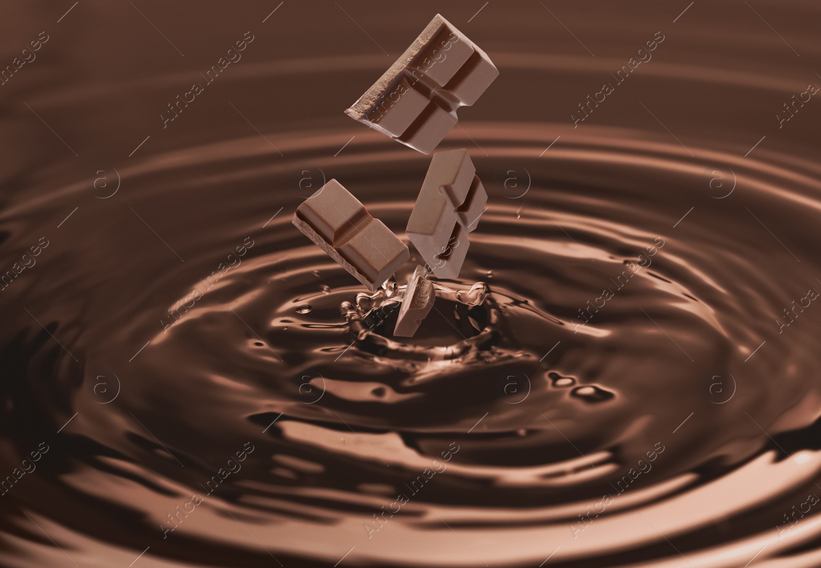 Image of Yummy melted chocolate with falling pieces as background
