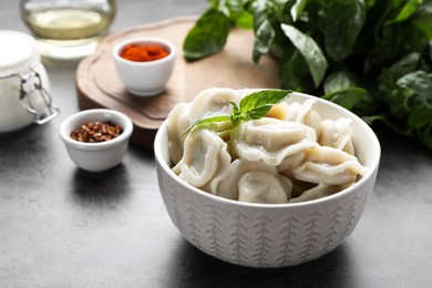 Tasty dumplings in bowl on served grey table