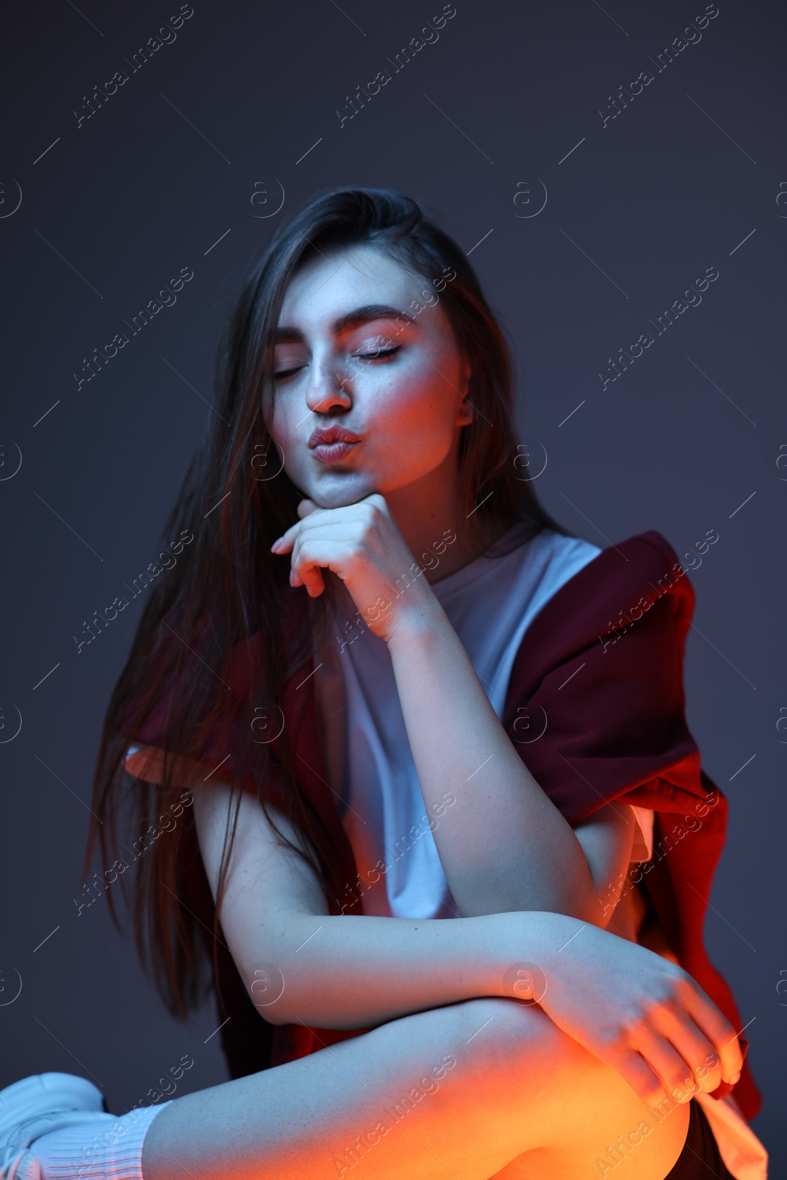Photo of Portrait of beautiful woman on dark blue background in neon lights