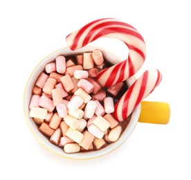 Photo of Cup of tasty cocoa with marshmallows and Christmas candy canes isolated on white, top view