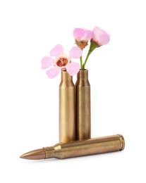 Photo of Bullet and cartridge cases with beautiful flowers isolated on white