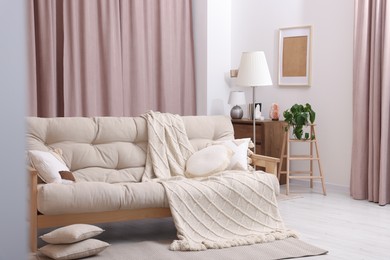 Photo of Comfortable sofa, cushions and blanket in cozy room. Interior design