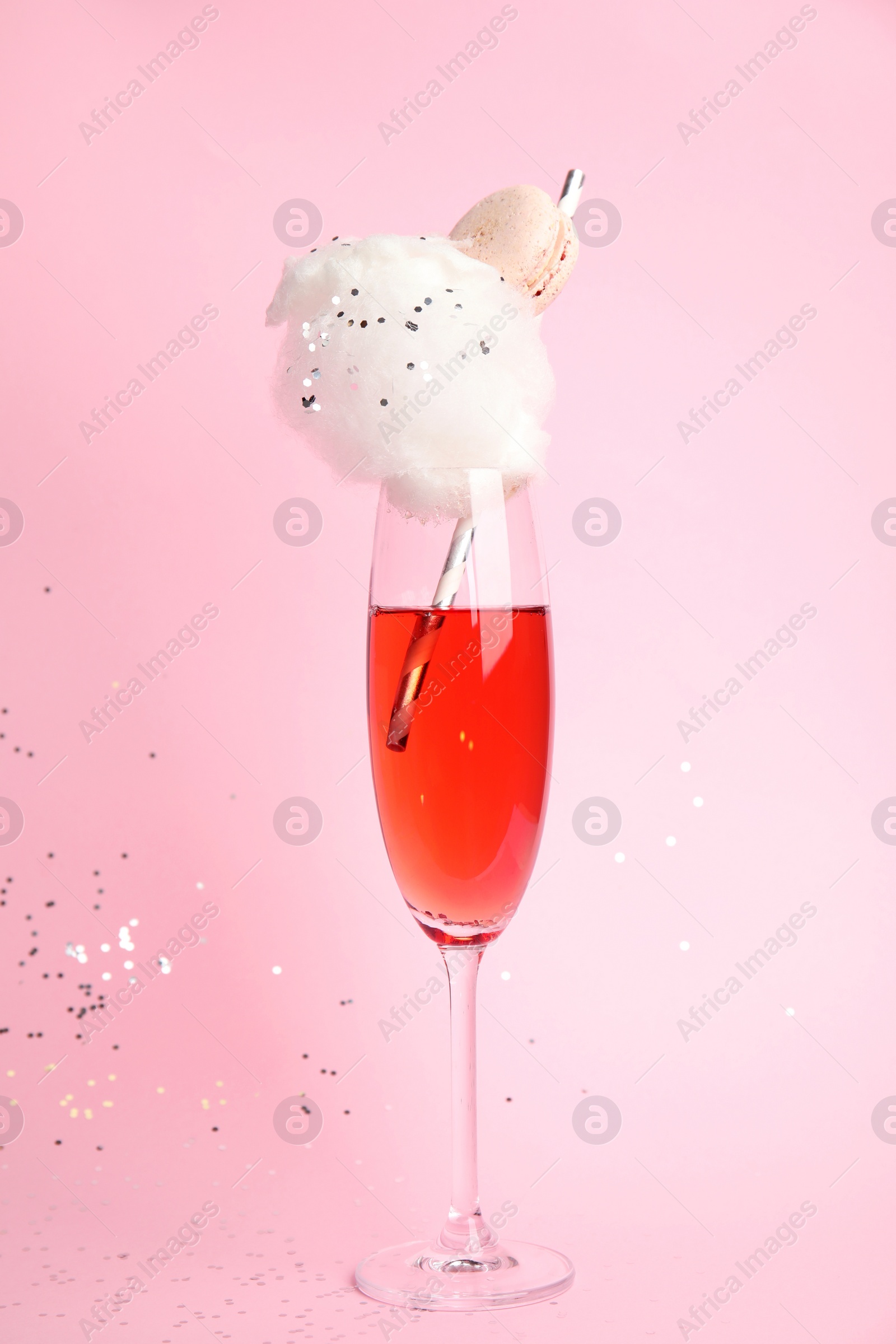 Photo of Cocktail with cotton candy in glass on pink background