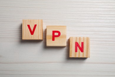 Cubes with acronym VPN on wooden table, flat lay