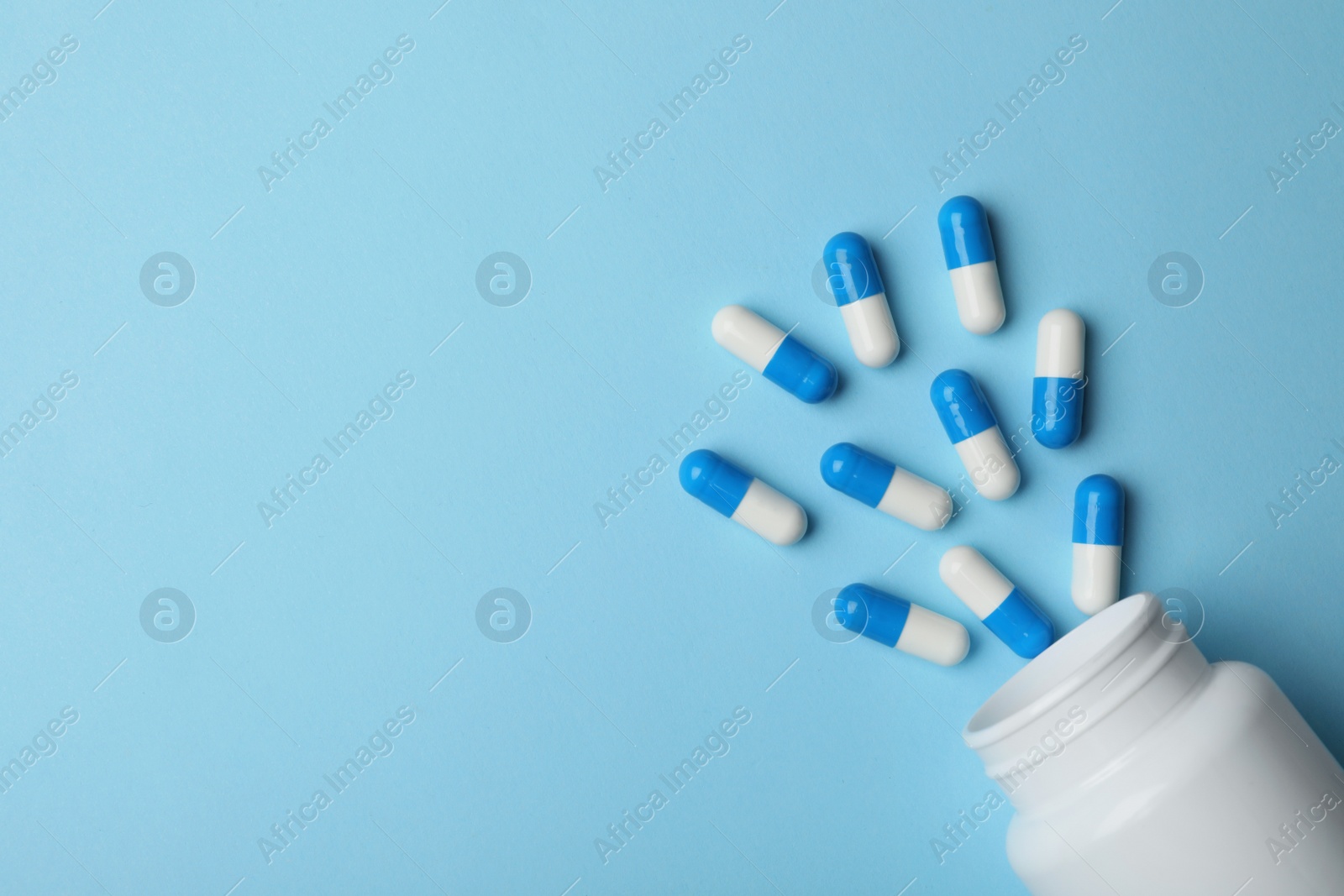 Photo of Bottle with pills on color background, flat lay. Space for text