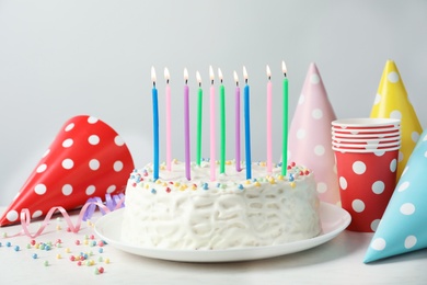 Photo of Delicious birthday cake with burning candles on table