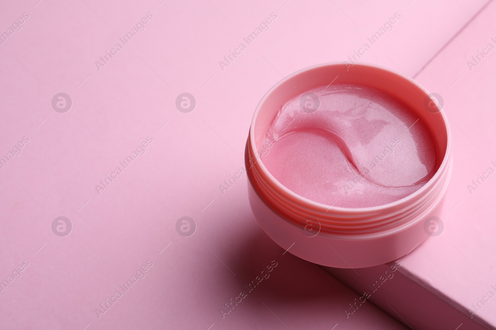 Photo of Package of under eye patches on pink background, space for text. Cosmetic product