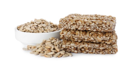 Photo of Delicious sweet kozinaki bars and sunflower seeds on white background