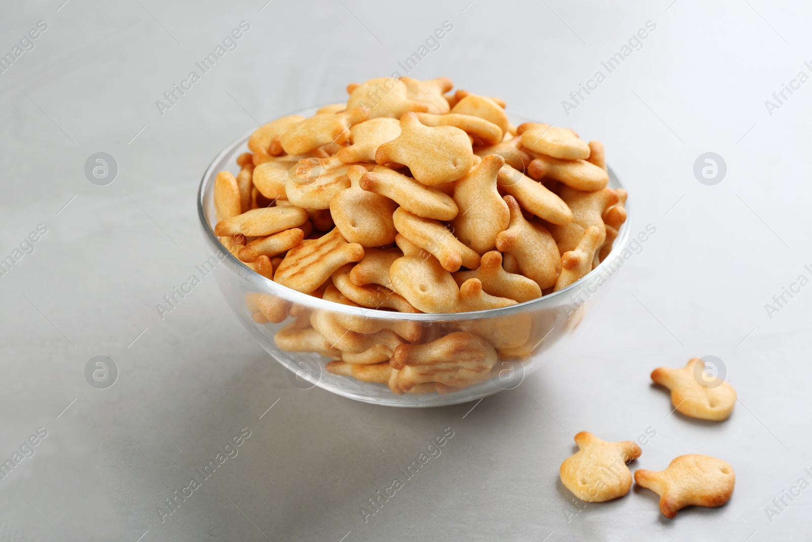 Photo of Delicious goldfish crackers in bowl on grey table