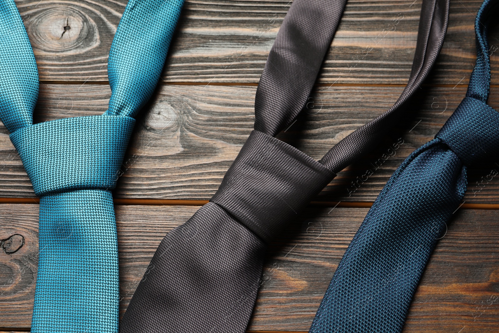 Photo of Different neckties on wooden table, flat lay