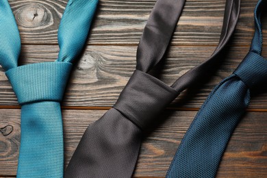Photo of Different neckties on wooden table, flat lay
