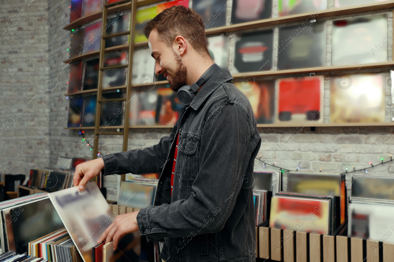 Image of Young man choosing vinyl records in store