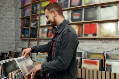 Young man choosing vinyl records in store