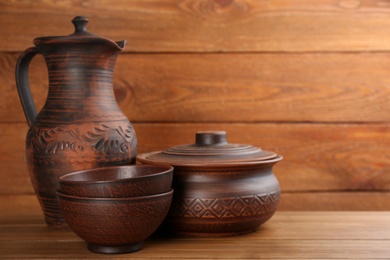 Photo of Set of clay utensils on wooden table