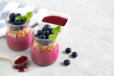 Tasty dessert with acai smoothie, granola and berries on marble table. Space for text