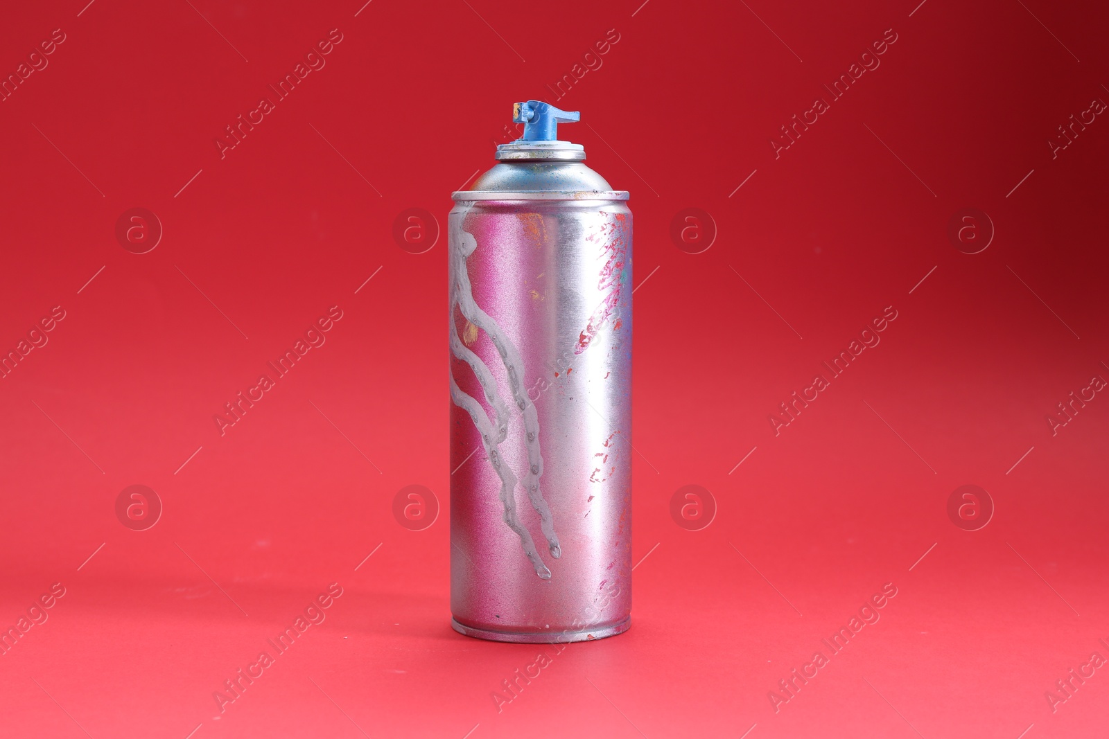 Photo of One can of bright spray paint on red background