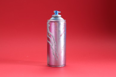Photo of One can of bright spray paint on red background