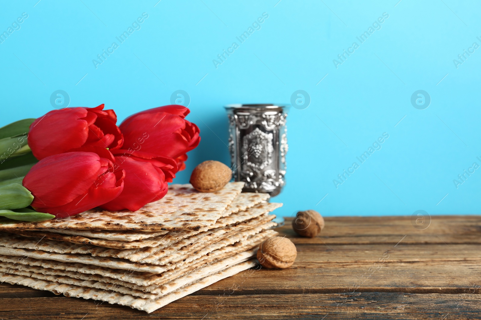 Photo of Composition with Passover matzos on wooden table, space for text. Pesach celebration
