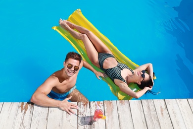 Photo of Happy young couple in outdoor swimming pool, above view