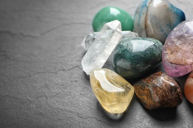 Photo of Different gemstones on grey table, closeup. Space for text