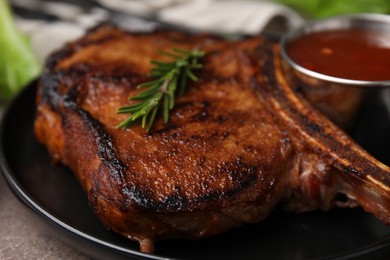 Photo of Tasty grilled meat, rosemary and marinade on table, closeup