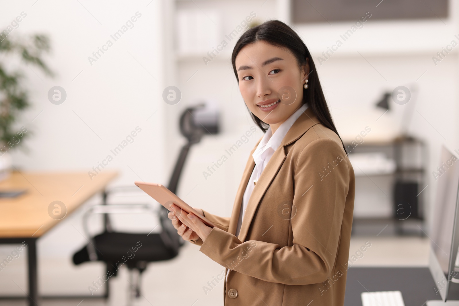 Photo of Portrait of smiling businesswoman with tablet in office. Space for text