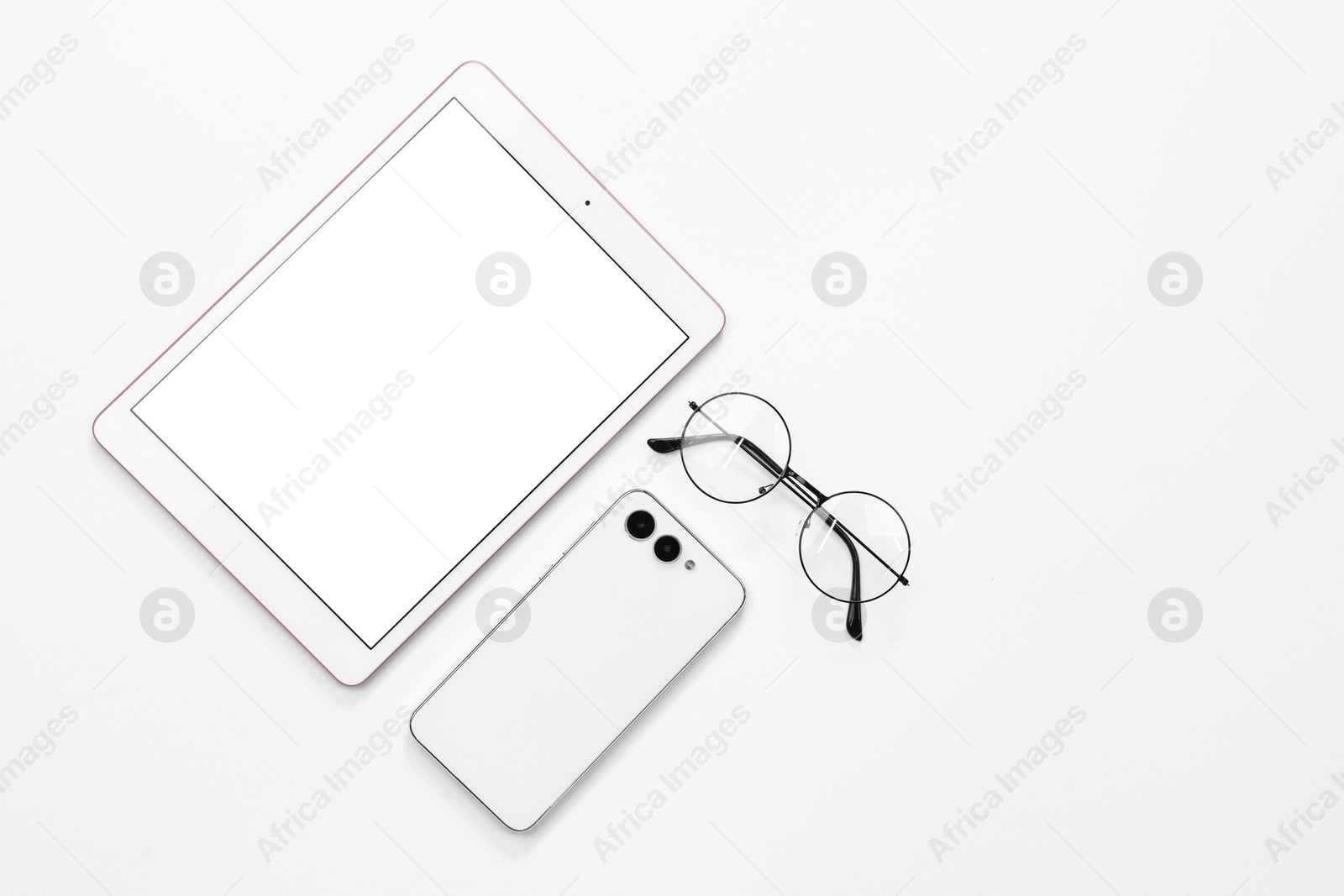 Photo of Modern tablet, smartphone and glasses on white background, flat lay. Space for text