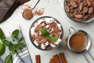 Photo of Glass of delicious hot chocolate with marshmallows and fresh mint on light grey marble table, flat lay