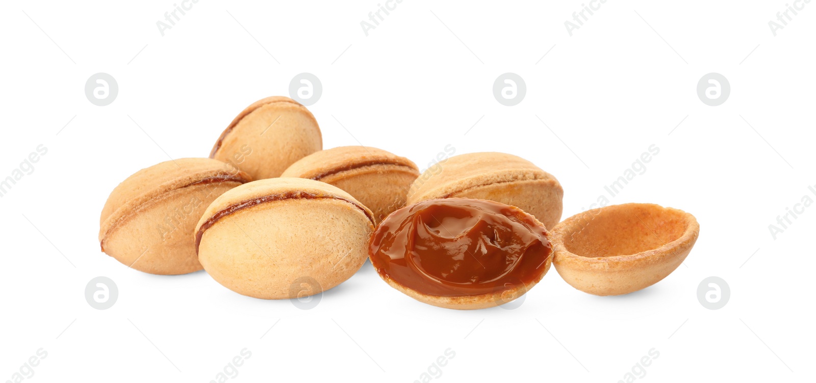 Photo of Delicious nut shaped cookies with boiled condensed milk on white background