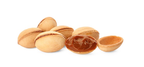 Photo of Delicious nut shaped cookies with boiled condensed milk on white background