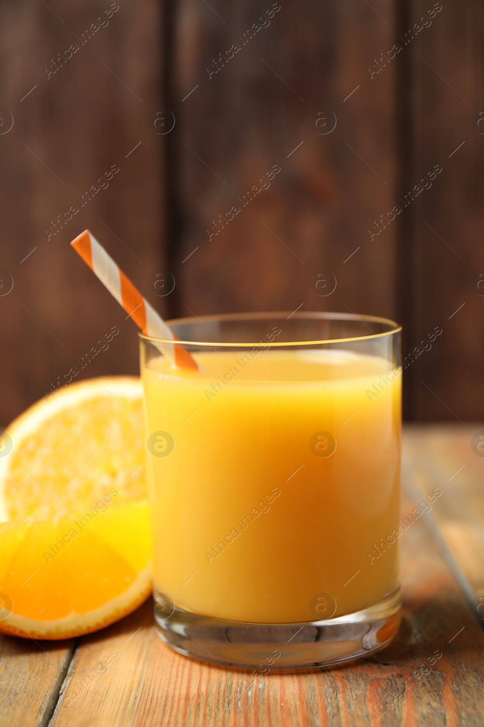 Photo of Glass of orange juice and fresh fruits on wooden table