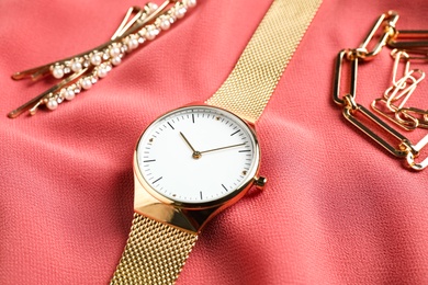 Luxury wrist watch on pink fabric, closeup