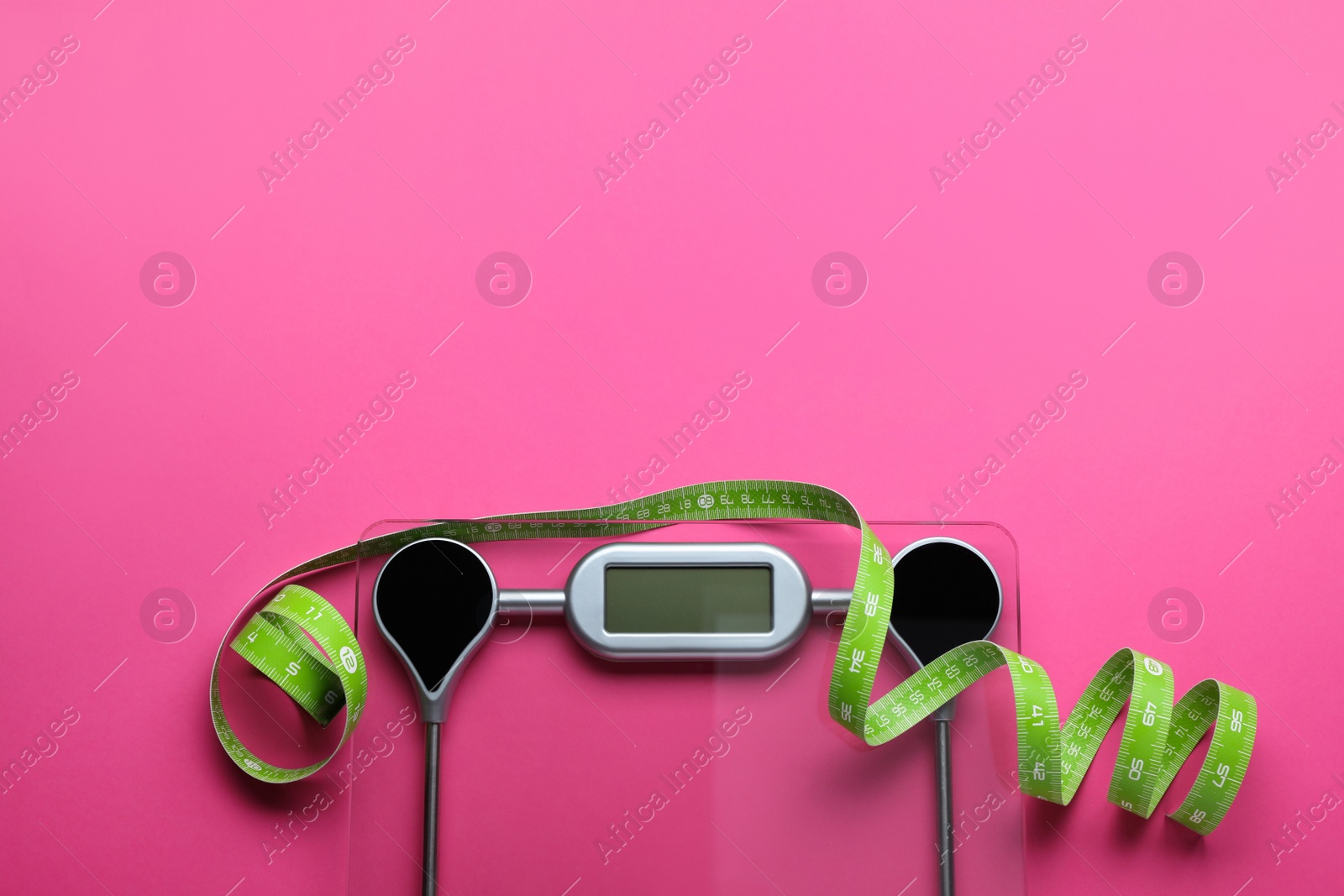 Photo of Electronic scales and measuring tape on pink background, flat lay. Space for text