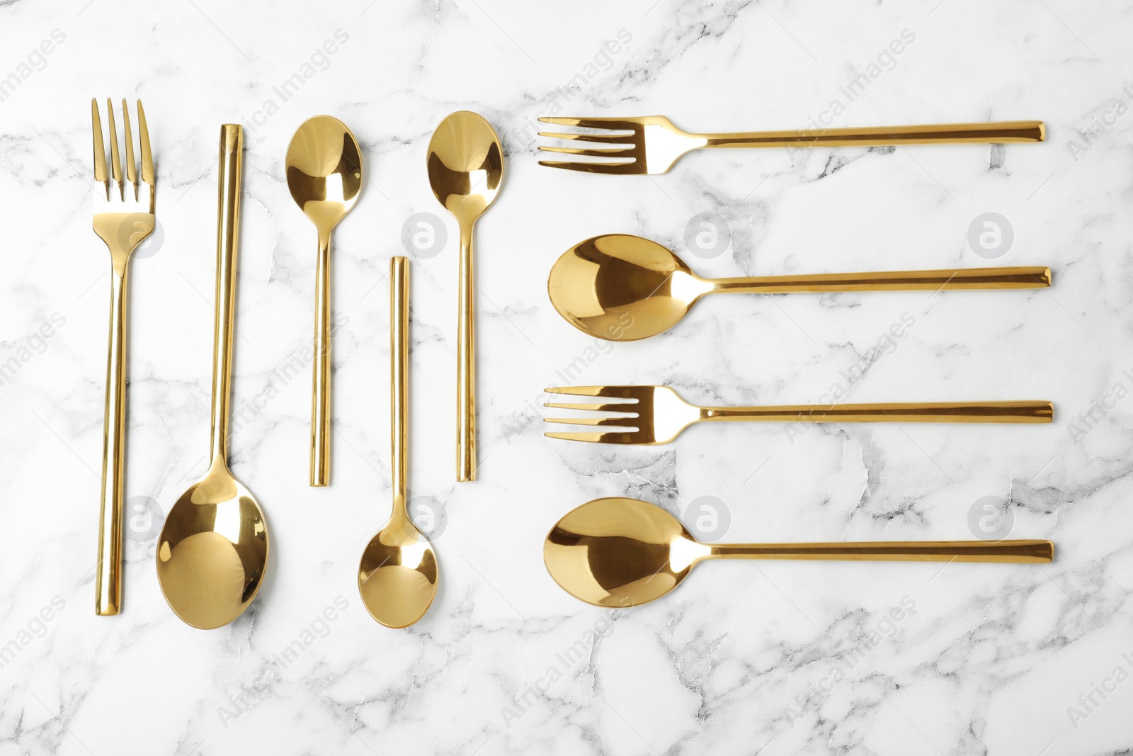 Photo of Set of new luxury cutlery on marble table, flat lay