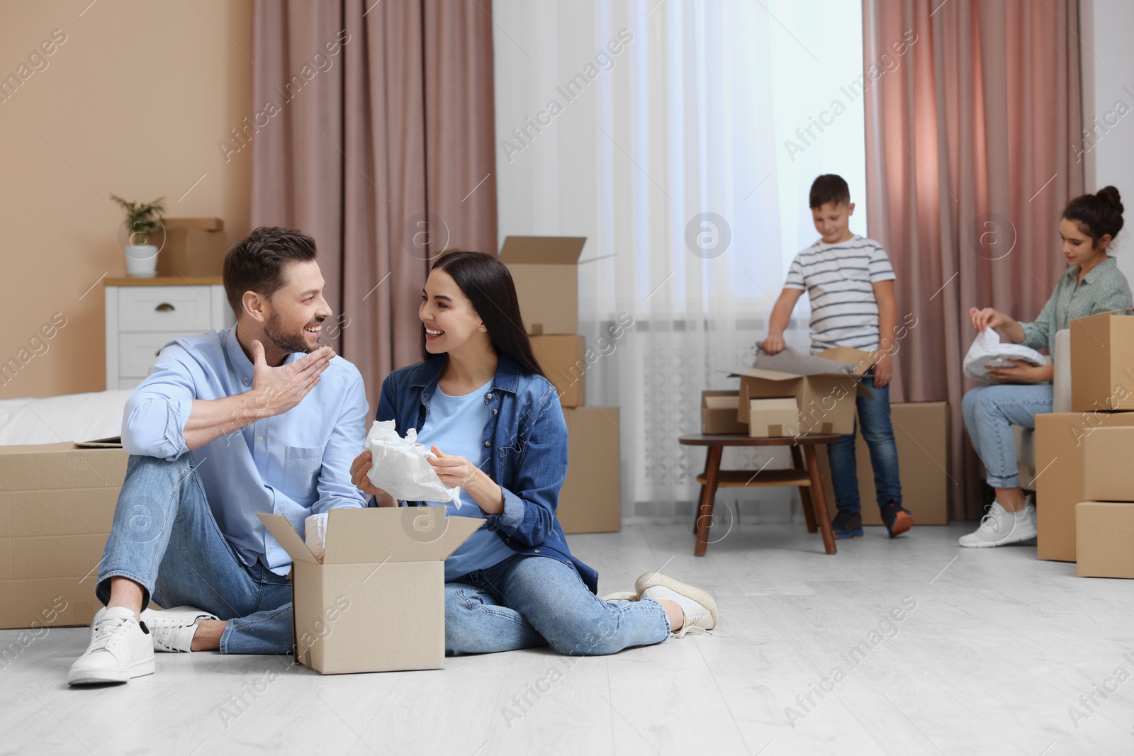 Photo of Happy family settling into new house and unpacking boxes. Moving day