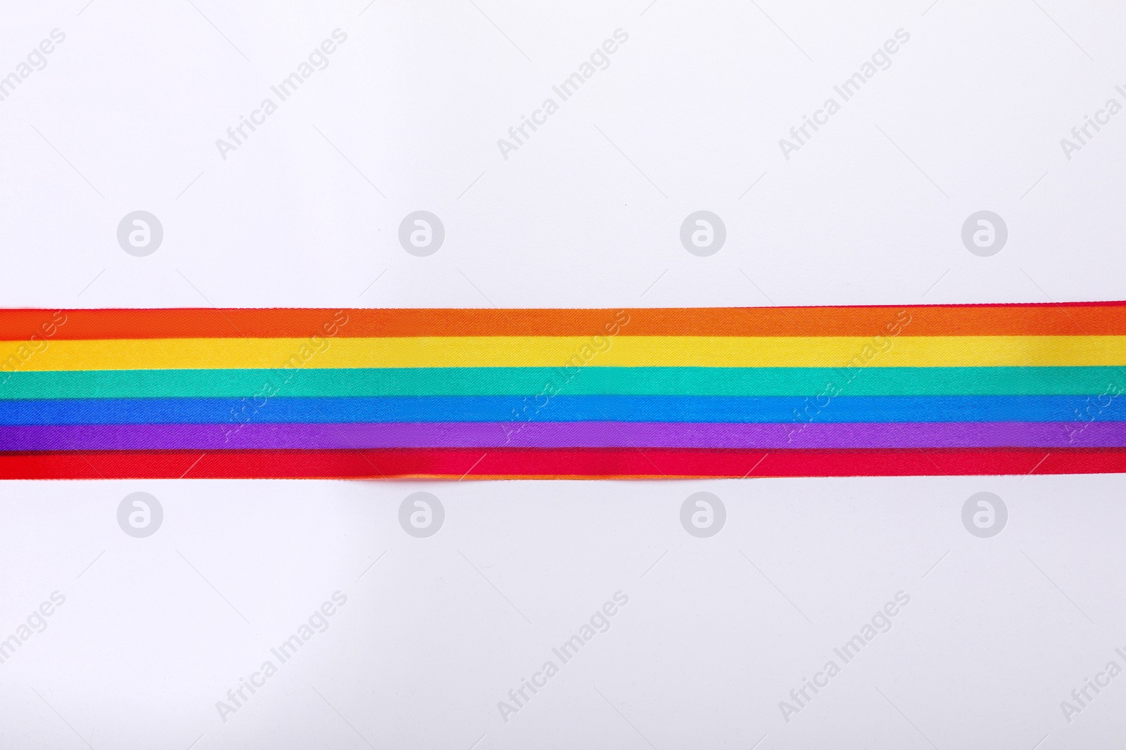 Photo of Rainbow ribbon on white background, top view. LGBT pride