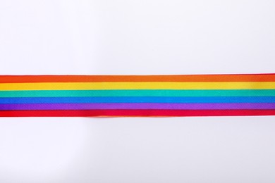 Photo of Rainbow ribbon on white background, top view. LGBT pride