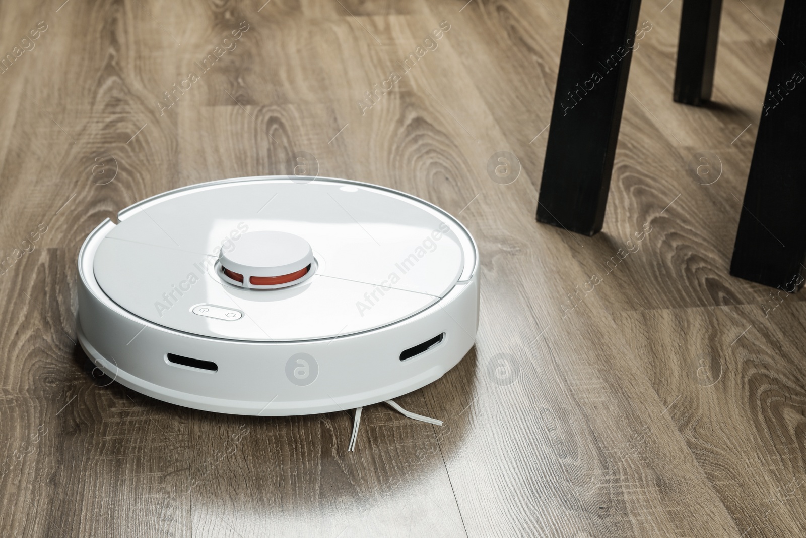 Photo of Robotic vacuum cleaner on wooden floor indoors