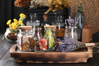 Photo of Many different herbs and dry lavender flowers on wooden table