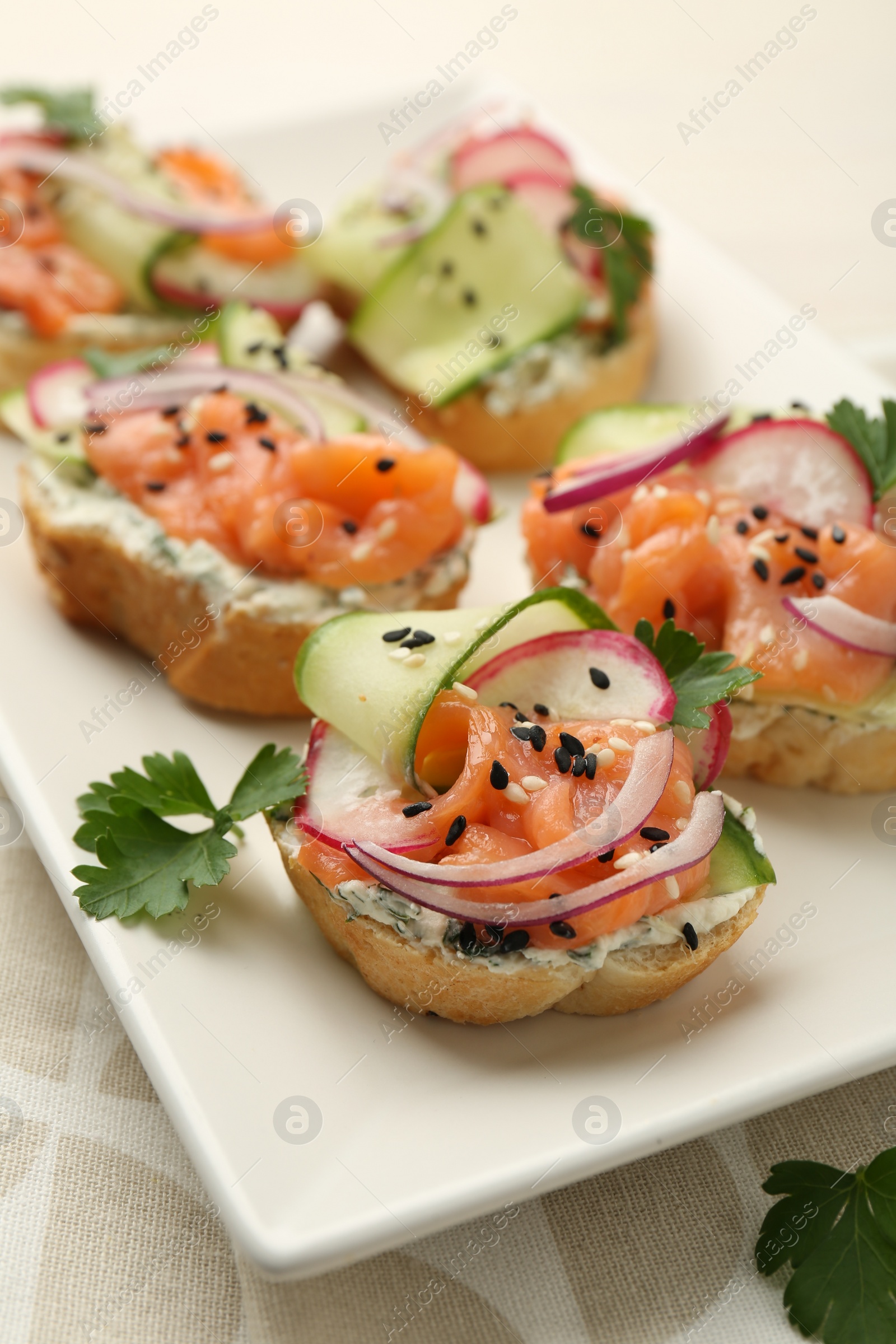 Photo of Tasty canapes with salmon served on table, closeup