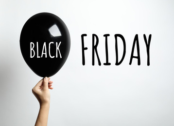 Black Friday concept. Woman holding balloon on white background, closeup