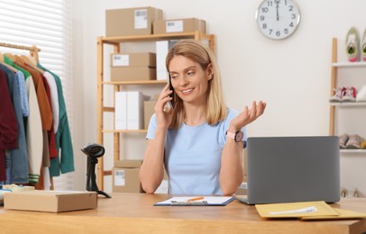 Seller talking on phone while working in office. Online store